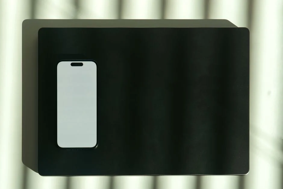 Un espace de travail moderne avec un smartphone affichant un écran et une configuration informatique, idéal pour les thèmes liés aux entreprises et à la technologie.